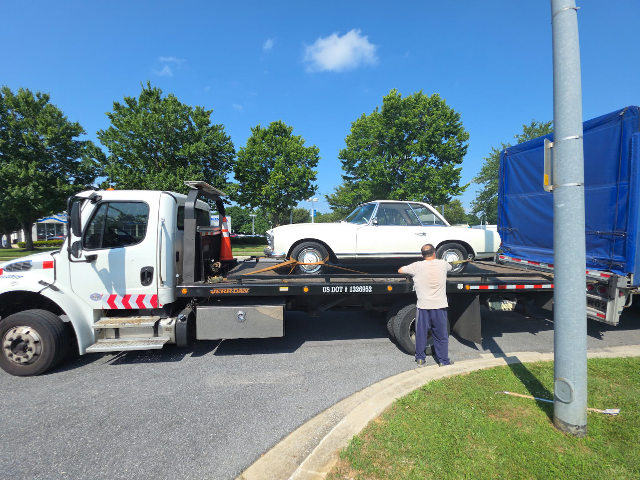 Car being loaded on flat bed truck for transport
